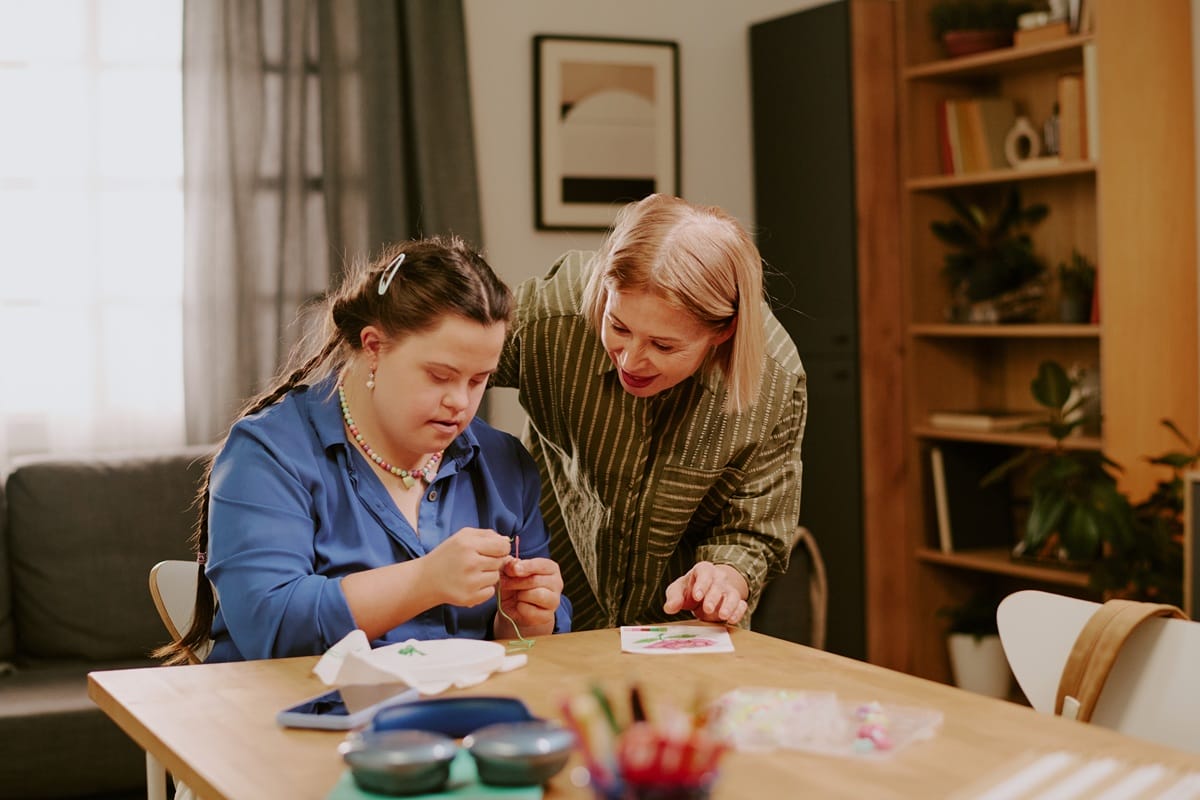 Woman Teaching Her Daughter With Disability How To Embroider